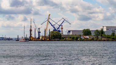 Rostock, Mecklenburg-Batı Pomerania, Almanya - 14 Haziran 2020: Vinçler ve bir liman yolcu gemisiyle limana bakın