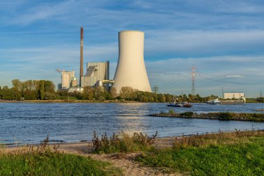 Duisburg, Kuzey Ren-Westfalia, Almanya - 26 Ekim 2019: Ren Nehri ve Walsum Enerji İstasyonu üzerinden bir gemi ve bir feribot geçen Orsoy manzarası