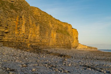 Llantwit Major Sahili 'nin taşları ve tepeleri akşam güneşiyle, Güney Glamorgan, Galler, İngiltere