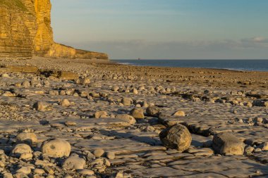 Llantwit Major Sahili 'nin taşları ve tepeleri akşam güneşiyle, Güney Glamorgan, Galler, İngiltere