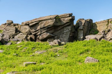 Doğu Midlands, Peak District, Derbyshire, İngiltere 'deki Hathersage yakınlarındaki Stanage Edge' de bir değirmen taşı.