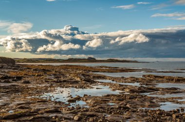 Northumberland kıyısında bulutlar, deniz evlerinden Bamburgh, İngiltere, İngiltere 'ye doğru bakıyor.