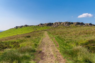 Doğu Midlands, Derbyshire, İngiltere 'de Hathersage yakınlarındaki Stanage Edge' e doğru yürüyor.