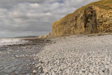 Güney Glamorgan, Galler 'deki Monknash Sahili' nde bulutlu bir günde taşlar ve uçurum.