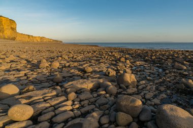 Llantwit Major Sahili 'nin taşları ve tepeleri akşam güneşiyle, Güney Glamorgan, Galler, İngiltere