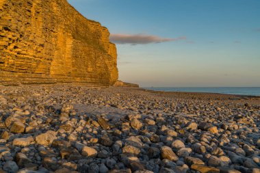 Llantwit Major Sahili 'nin taşları ve tepeleri akşam güneşiyle, Güney Glamorgan, Galler, İngiltere