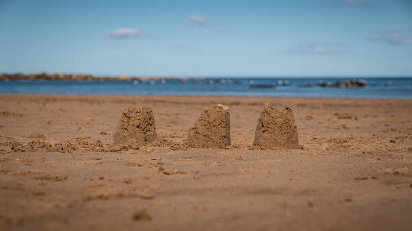 Песчаные замки на пляже Рансвик-Сэндс, Северный Йоркшир, Англия, Великобритания - на фоне Северного моря