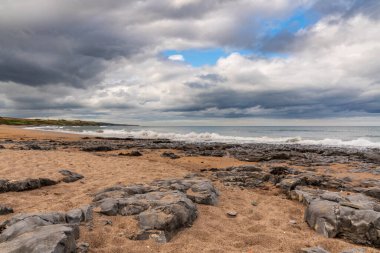 Northumberland, İngiltere 'deki Berwick-upon-Tweed yakınlarındaki Cocklawburn Sahili' nde kara bulutlar ve büyük taşlar görülüyor.