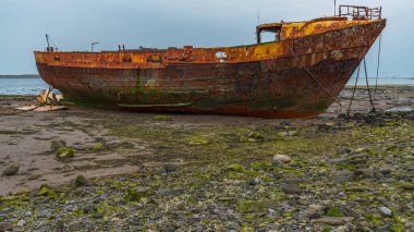 Walney Kanalı 'nın çamurunda paslı bir gemi enkazı, Roa Adası, Cumbria, İngiltere, İngiltere' ye giden yoldan görülüyor.