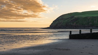 Akşam havası ve kumsaldaki kara bulutlar ve Cumbria, İngiltere 'deki Whitehaven yakınlarındaki St Bees Heritage Sahili.