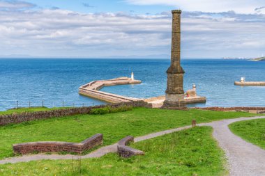 Arka planda, Whitehaven, Cumbria, İngiltere 'de görülen, iskelesi West Pier Lighthouse ve arka planda North Pier Lighthouse olan şamdan bacası.