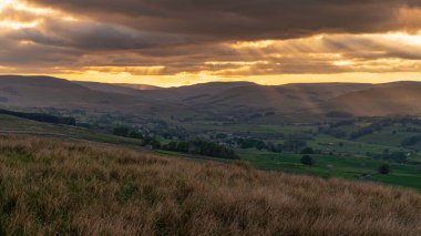 Countersett, North Yorkshire, İngiltere yakınlarındaki Yorkshire Dales 'de bulutlu bir gün batımı