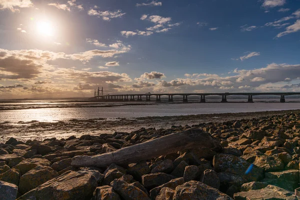セブンビーチ サウスグロスターシャー イングランド 英国から見られる夕日とウェールズ橋の王子と流木の作品 — ストック写真