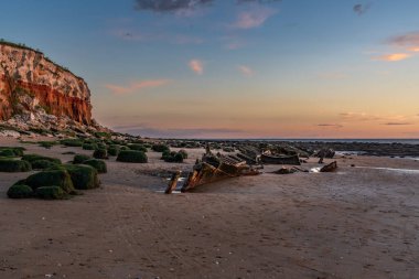 İngiltere, Norfolk 'taki Hunstanton Cliffs' de akşam ışığında Buharlı Tramvay Enkazı Sheraton.