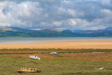 Çimlerde tekneler, göldeki ulusal parkın arka planında bulutlar, Askam-in-Furness, Cumbria, İngiltere, İngiltere