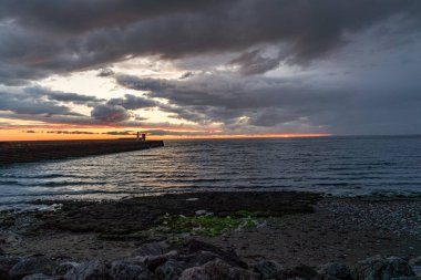Günbatımından sonra, Whitehaven, Cumbria, İngiltere 'deki Kuzey İskelesi Deniz Feneri' nde kara bulutlar var.
