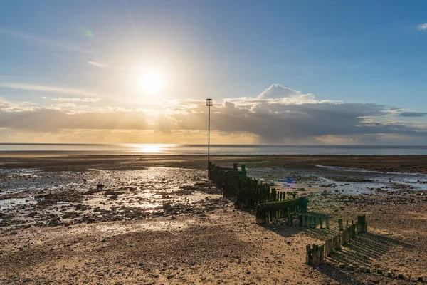 イギリス ノーフォーク州ヒーカムのノースビーチにあるグロインズと夕日 — ストック写真