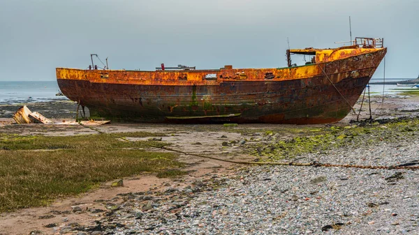 Walney Kanalı 'nın çamurunda paslı bir gemi enkazı, Roa Adası, Cumbria, İngiltere, İngiltere' ye giden yoldan görülüyor.