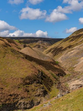 Arka planda Bunton Madeni ve Blakethwaite Madeni ile Gunnerside Gill 'de yürümek, Kuzey Yorkshire, İngiltere, İngiltere