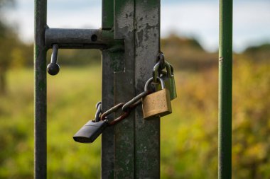 Kapısında iki asma kilit olan demir bir zincir.