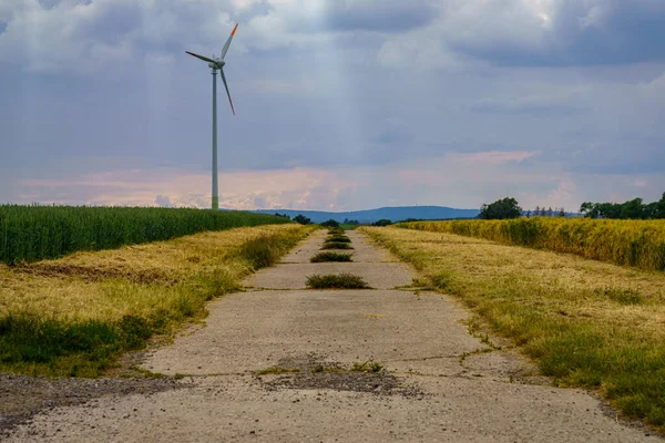 德国下萨克森州阿尔滕哈根附近一条带风车穿过田野的乡村道路 — 图库照片