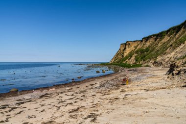Plajda boş bir plastik sandalyeyle Baltık Denizi kıyısı ve Boltenhagen, Mecklenburg-Batı Pomerania uçurumları, Almanya
