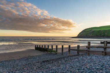 Akşam havası ve kumsaldaki kara bulutlar ve Cumbria, İngiltere 'deki Whitehaven yakınlarındaki St Bees Heritage Sahili.