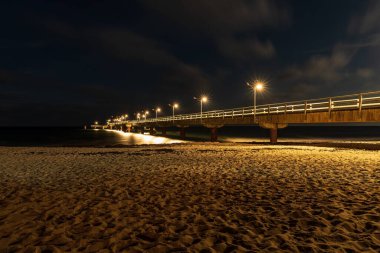 Karanlık çöktükten sonra sahil ve iskele, Goehren, Mecklenburg-Batı Pomerania, Almanya 'da görülüyor.