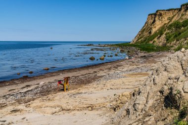 Plajda boş bir plastik sandalyeyle Baltık Denizi kıyısı ve Boltenhagen, Mecklenburg-Batı Pomerania uçurumları, Almanya