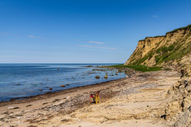 Plajda boş bir plastik sandalyeyle Baltık Denizi kıyısı ve Boltenhagen, Mecklenburg-Batı Pomerania uçurumları, Almanya