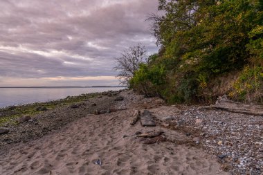 Akşam Jasmunder Bodden sahilinde Lietzow yakınlarındaki çakıl taşı plajında, Mecklenburg-Batı Pomerania, Almanya