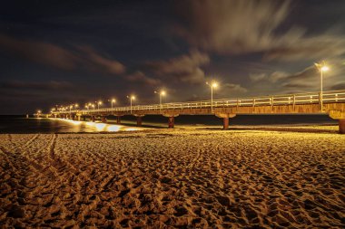 Karanlık çöktükten sonra sahil ve iskele, Goehren, Mecklenburg-Batı Pomerania, Almanya 'da görülüyor.