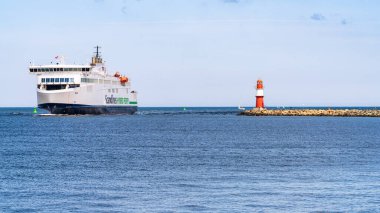 Rostock, Mecklenburg-Batı Pomerania, Almanya - 14 Haziran 2020: Gedser 'den Rostock' a giden bir Scandline feribotu, Warnemuende 'deki doğu rıhtımındaki deniz fenerini geçiyor.