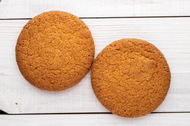 İki leziz yuvarlak Amerikan kurabiyesi, yakın plan, ahşap bir masanın üstünde, üst manzara..