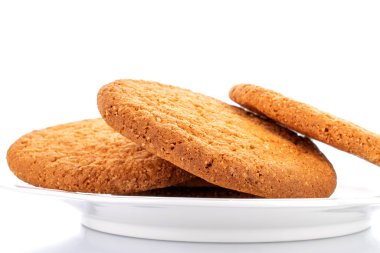 Seramik bir tabakta yeni pişmiş birkaç Amerikan kurabiyesi, yakın plan, beyaz üzerinde izole edilmiş..