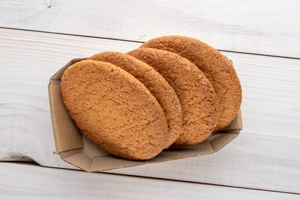 Kağıt bir kutuda, ahşap bir masanın üstünde, üst manzaralı birkaç lezzetli yuvarlak Amerikan kurabiyesi..
