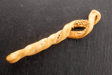 Tahtada susamlı Grissini ekmeği var. Yakın çekim, üst manzara..