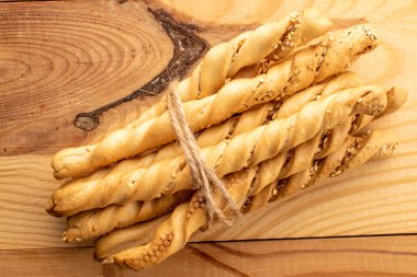 Grissini ekmek çubukları susam tohumlu, yakın plan, ahşap masa, üst manzara.
