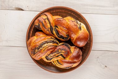 İki güzel kokulu haşhaş tohumu çöreği ve ahşap bir masa, makro, üst manzara..