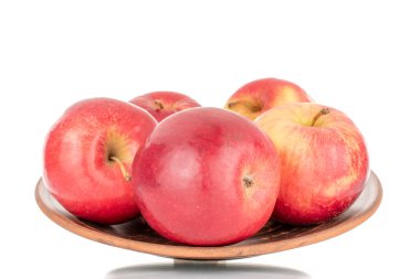 Birkaç sulu, olgun, kırmızı elma bir tabak kil, makro, beyaz arka planda izole.