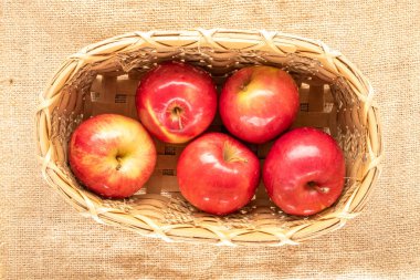 Çuval bezinde, makroda, sepetin içinde birkaç sulu, organik, kırmızı elma..