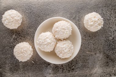 Metal tepside seramik tabağı olan hindistan cevizi taneli birkaç lezzetli tatlı, yakın plan, üst manzara..