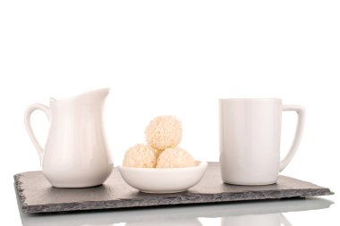 Beyaz arkaplanda izole edilmiş beyaz seramik tabaklar ve hindistan cevizi parçacıkları olan bir şeker..