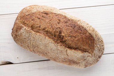 Bir somun taze ekmek, yakın plan, ahşap bir masa, üst manzara..