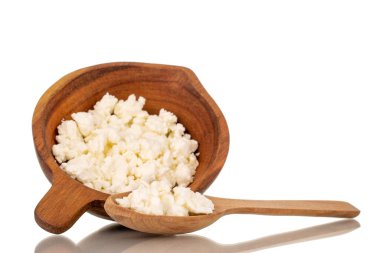 Ahşap bir fincanda, beyaz bir arka planda izole edilmiş, ahşap bir kaşıkla güzel kokulu süzme peynir..