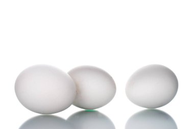 Üç tavuk yumurtası, makro, beyaz arka planda izole edilmiş..