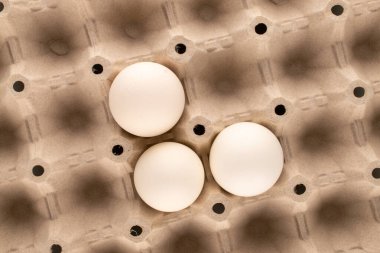 Tepside üç beyaz tavuk yumurtası, makro, üst manzara..