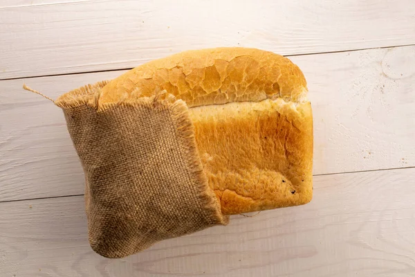 Jeden Bochník Příchutí Pšeničného Chleba Jutovým Ubrouskem Dřevěném Stole Zblízka — Stock fotografie