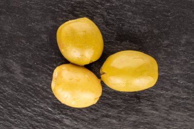 Üç baharatlı organik turşulu yeşil zeytin, arka planda koyu renk, üst manzara..