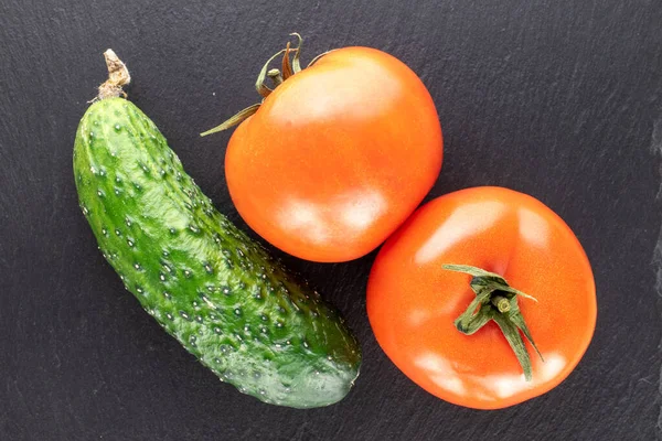 İki organik domates ve bir salatalık, kayrak taşı, makro, üst manzara..